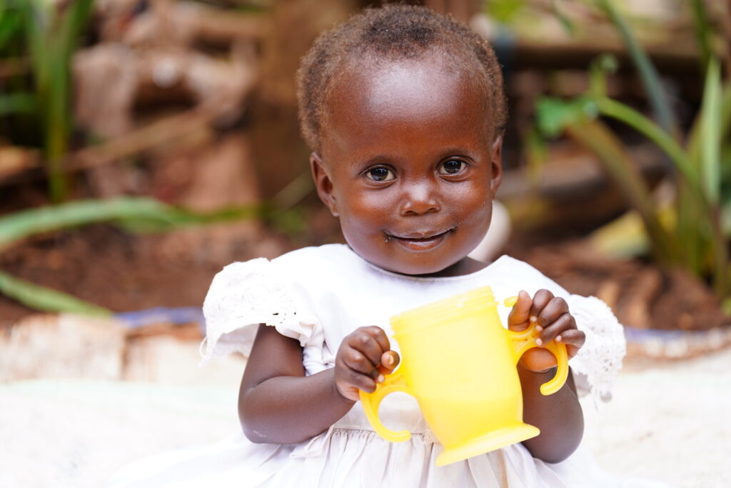 Little girl holding mug.
